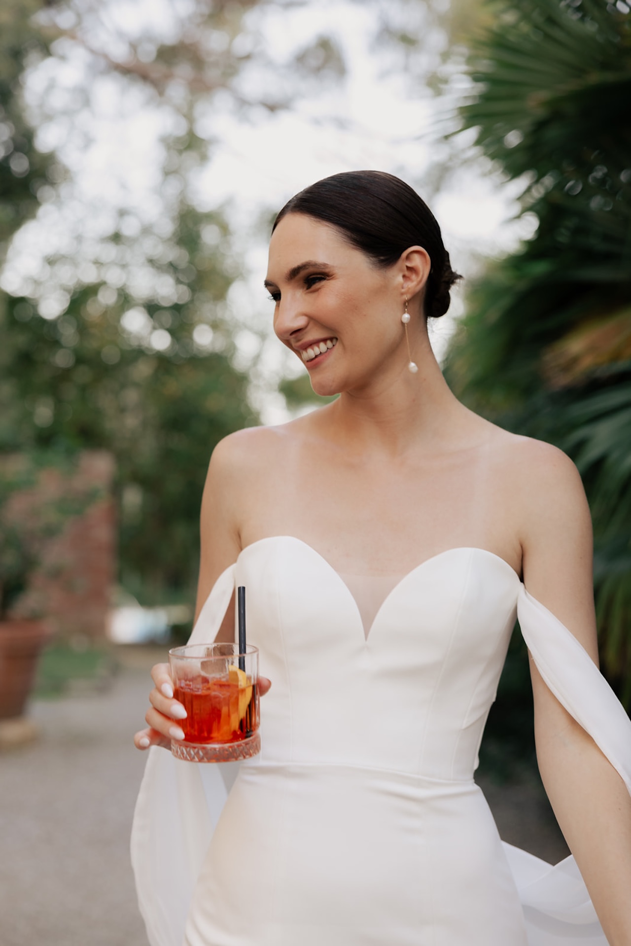 Sposa sorridente con il cocktail in mano